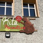 handgemaltes Kita-Schild an der Wand - Kita Murmeltiere Auftragsarbeit - Schildermalerei