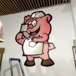 Graffiti Auftragsarbeit, Comic-Schweinchen, Restaurant Wanddesign